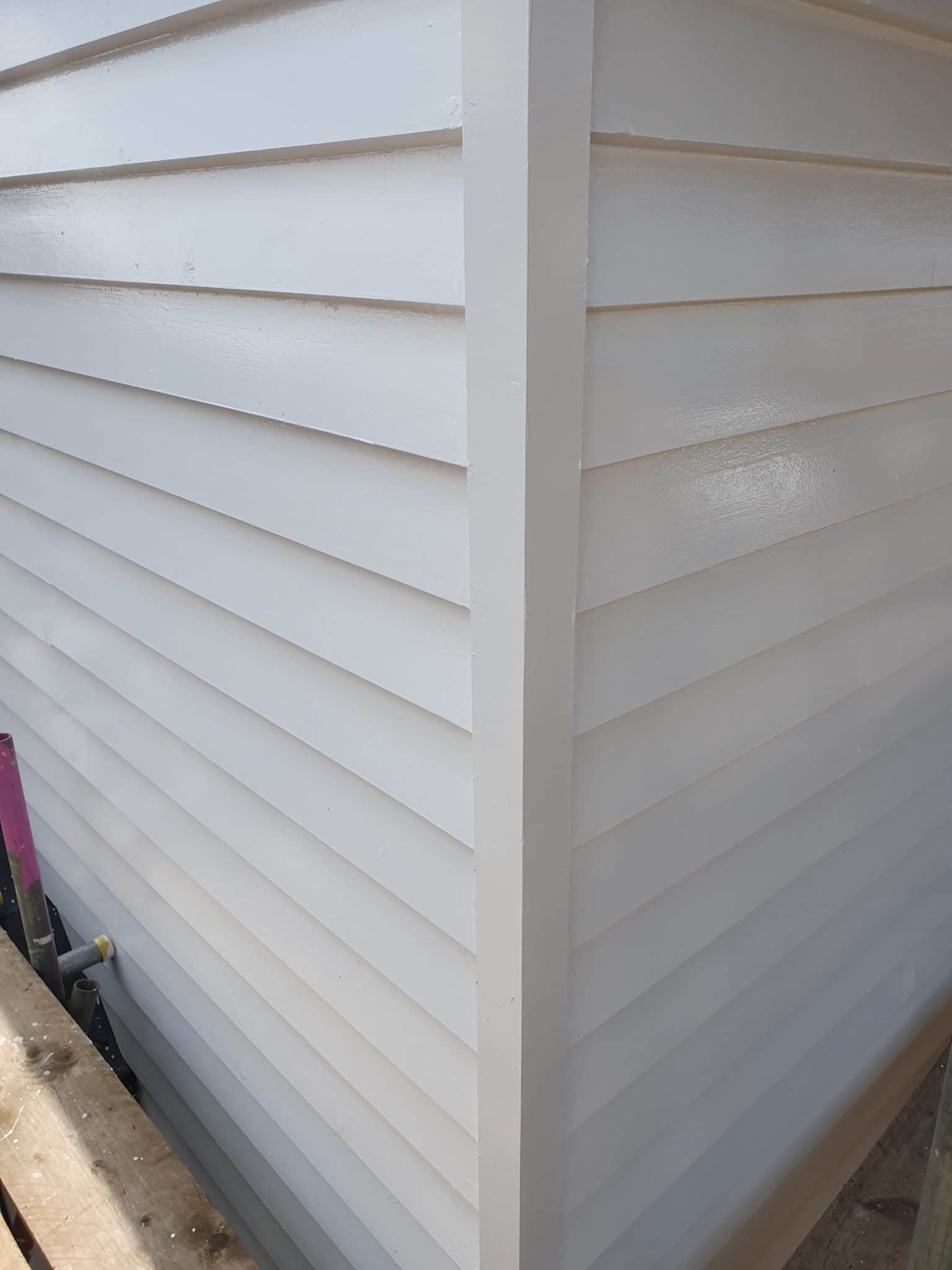 Corner of a house in freshly painted white weatherboarding