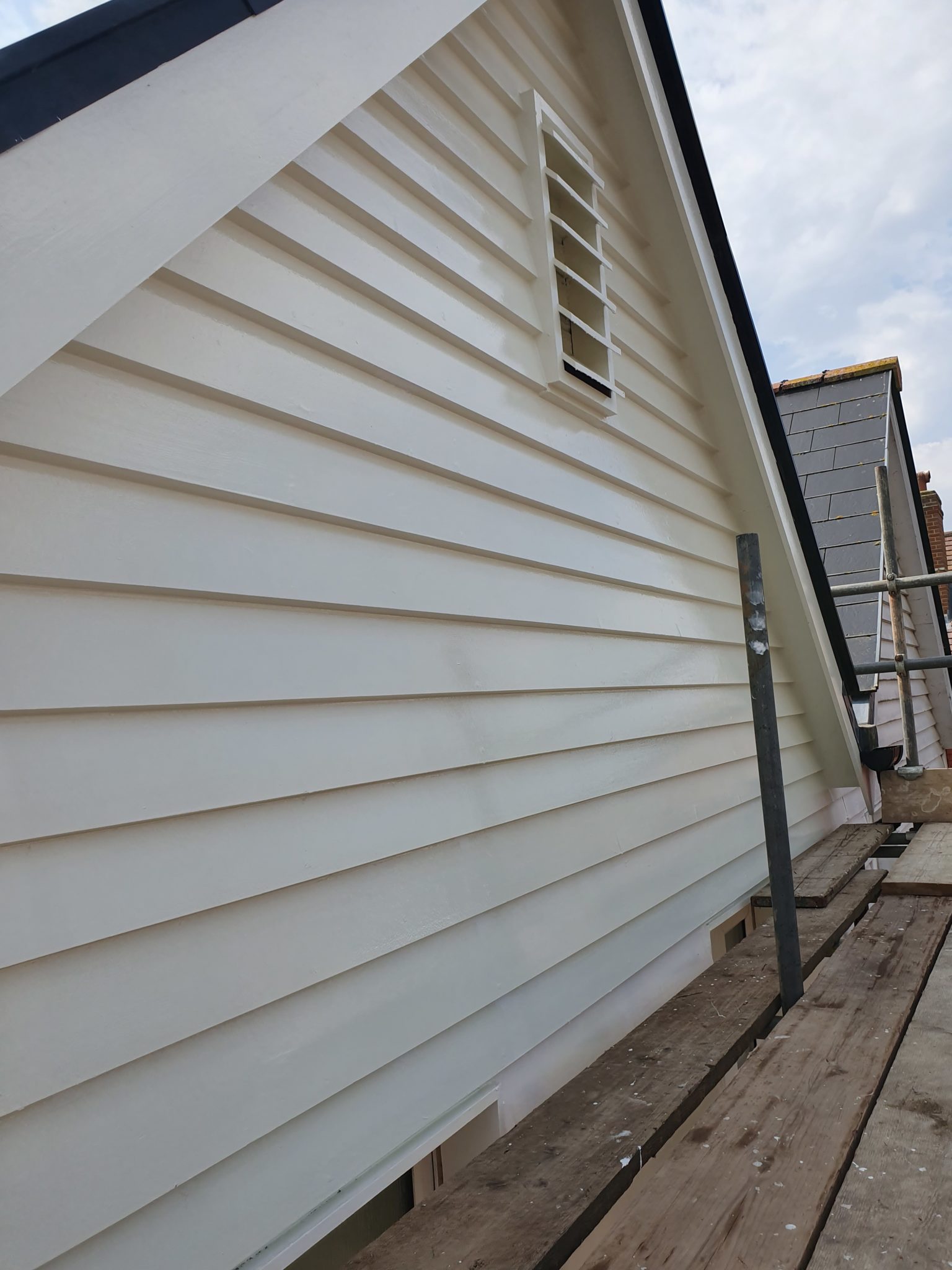 White painted weatherboarding on the side of a house