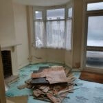 Room with old flooring lifted, a bay window and an open fireplace