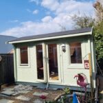 Sage green painted garden room with glazed double doors