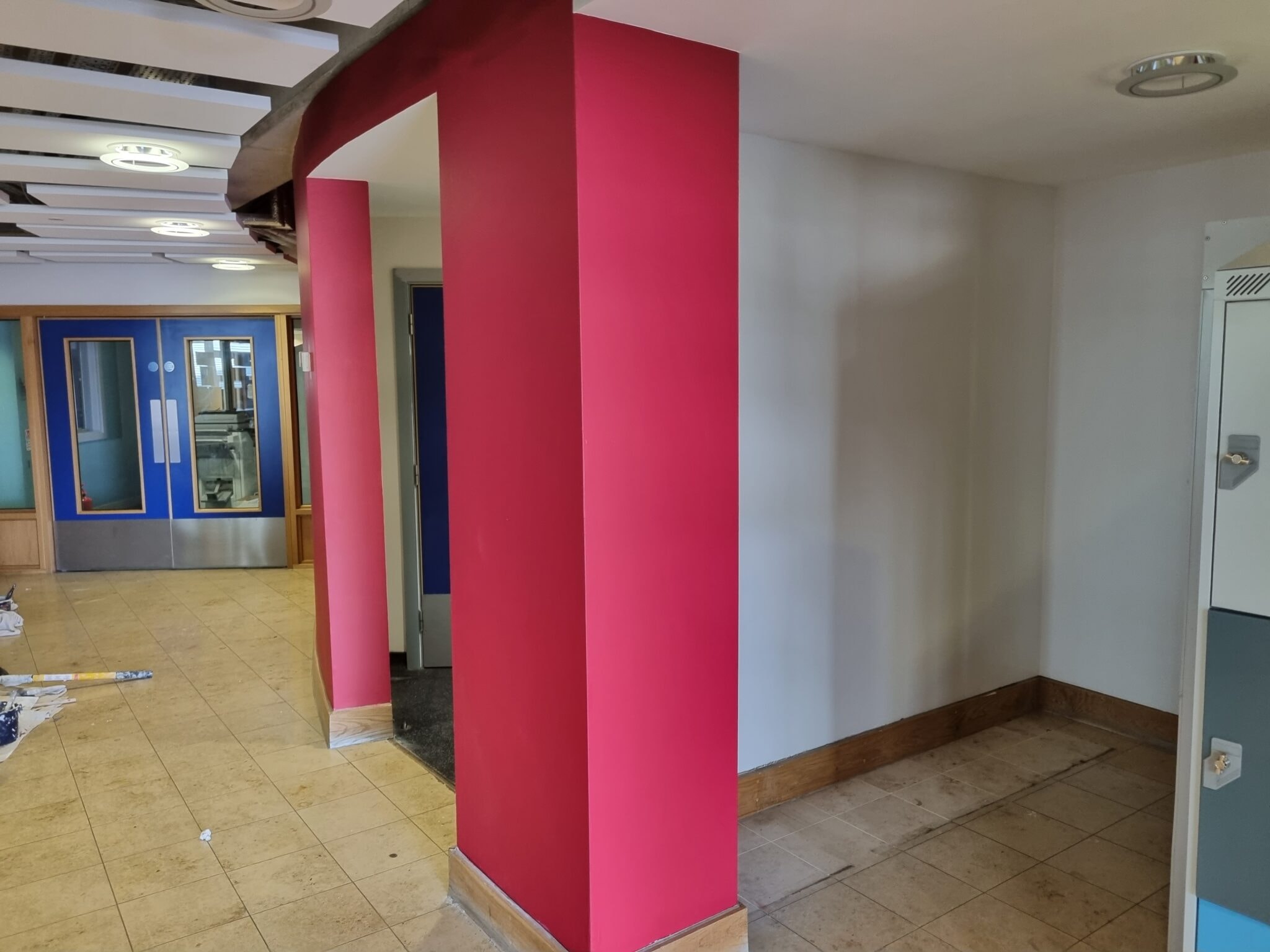 Office with a bright pink painted column and white walls