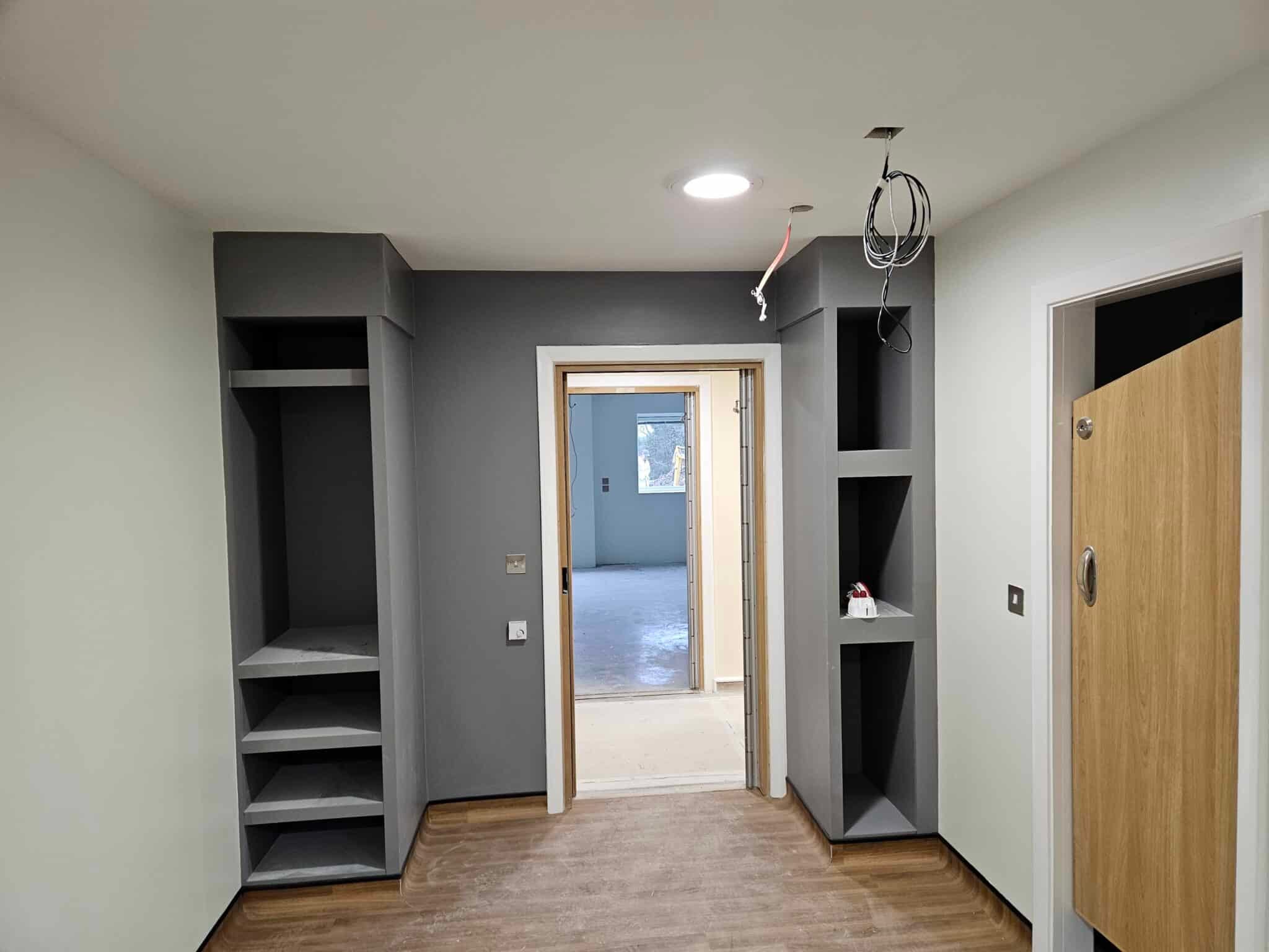 Grey painted built-in shelving either side of a doorway