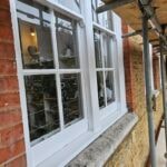 White painted timber windows behind scaffolding poles