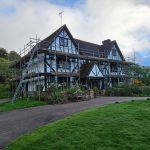 Black and white timber-framed house with scaffolding along its front