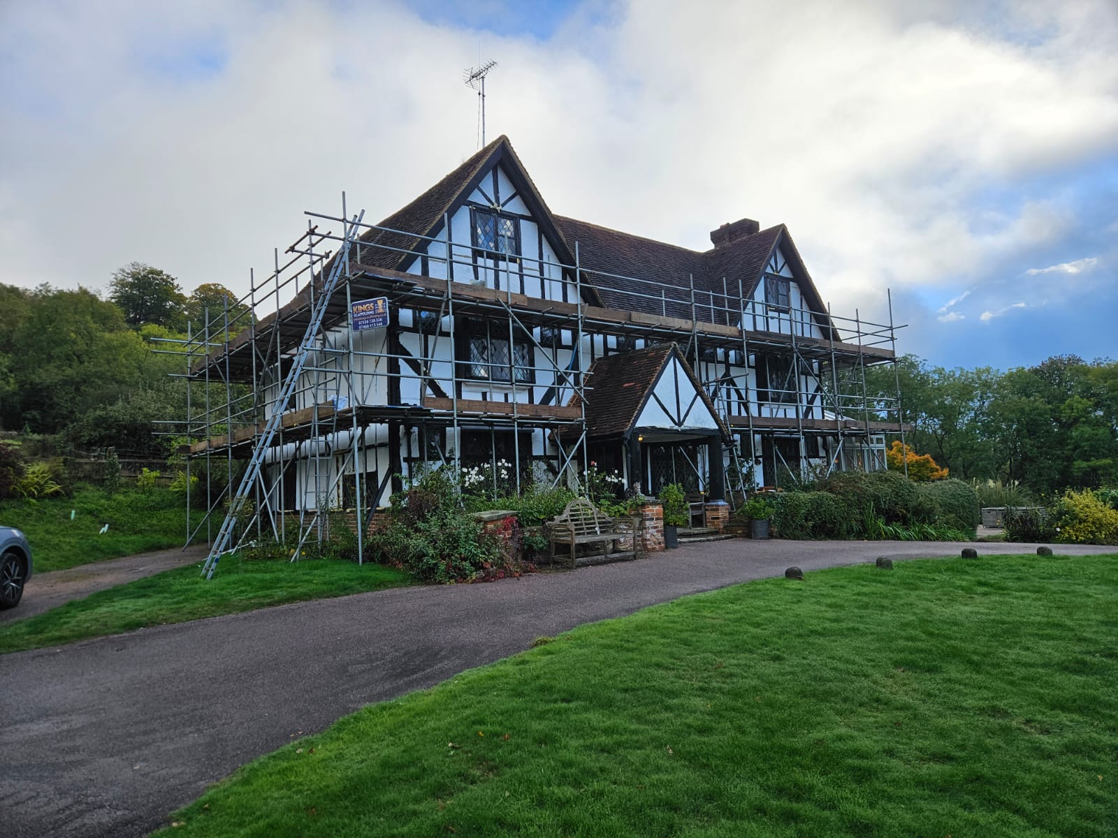 Black and white timber-framed house with scaffolding along its front