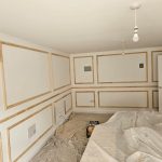 Wall panelling strips fixed to a living room wall before painting