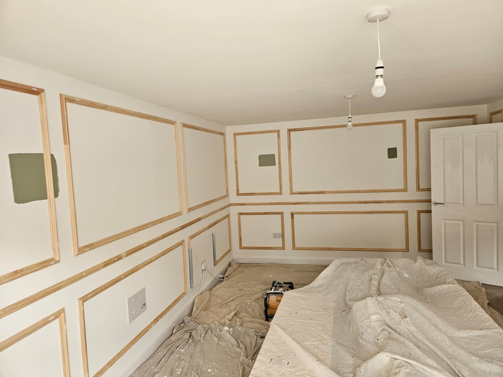 Wall panelling strips fixed to a living room wall before painting